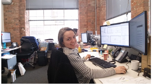 Picture of Maya sitting at her office desk